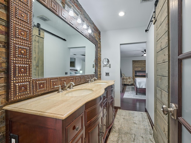 ensuite bathroom featuring ensuite bathroom, ceiling fan, a sink, and decorative backsplash