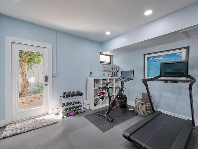 workout room with recessed lighting, a healthy amount of sunlight, a textured wall, and cooling unit