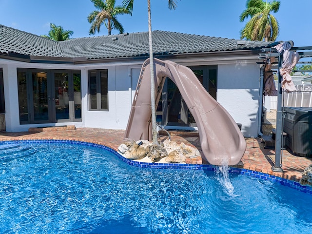 pool with french doors and a patio area