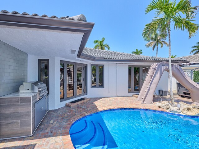 pool with an outdoor kitchen, an outdoor living space, a gazebo, french doors, and a patio area