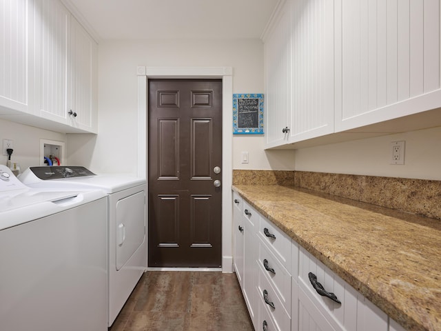 clothes washing area with dark wood-style flooring, cabinet space, and washer and clothes dryer