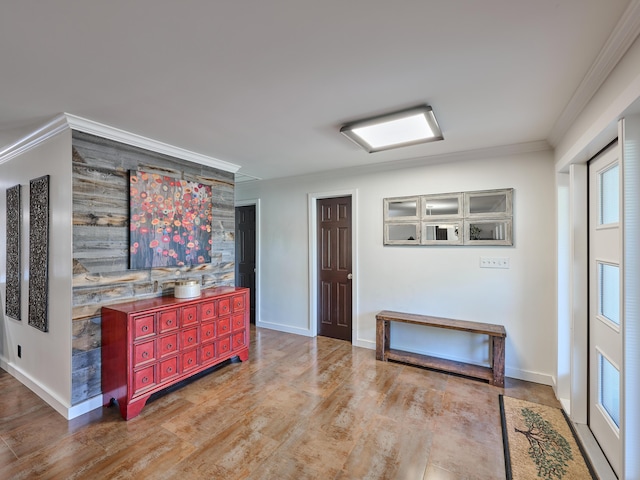 interior space with baseboards, crown molding, and wood finished floors