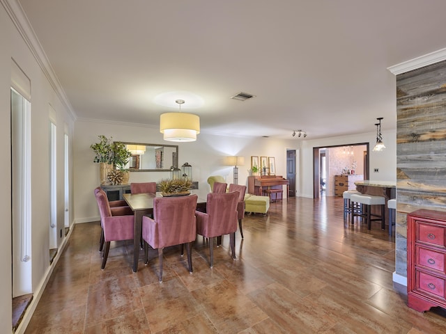 dining area with baseboards, visible vents, and crown molding