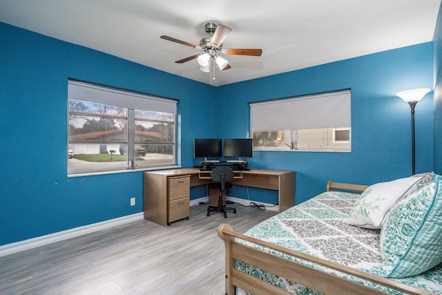 bedroom featuring ceiling fan, baseboards, and wood finished floors