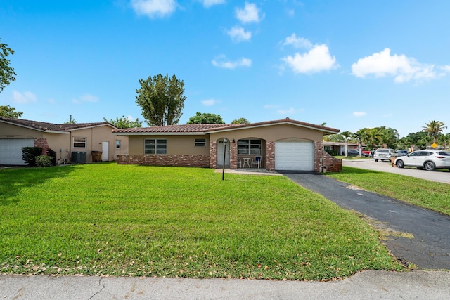 ranch-style house featuring aphalt driveway, an attached garage, central AC, stucco siding, and a front lawn