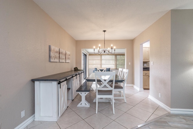 dining space featuring baseboards, a textured wall, light tile patterned flooring, and a notable chandelier