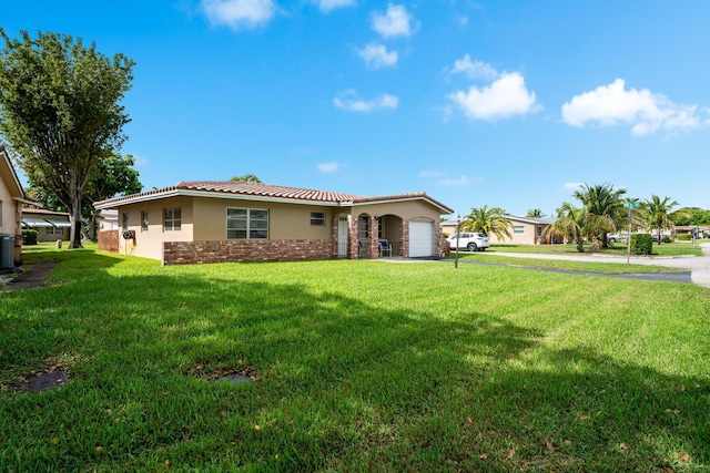 view of front of property with an attached garage, stucco siding, a front lawn, and a tiled roof