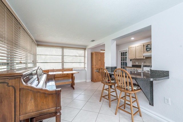 dining area featuring light tile patterned flooring, visible vents, and baseboards