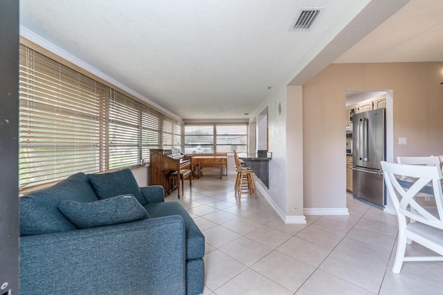 living room featuring light tile patterned flooring, visible vents, and baseboards