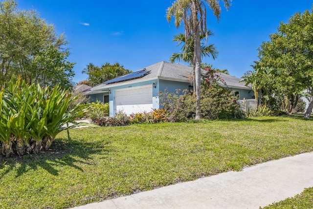 view of property exterior featuring an attached garage, stucco siding, roof mounted solar panels, and a yard