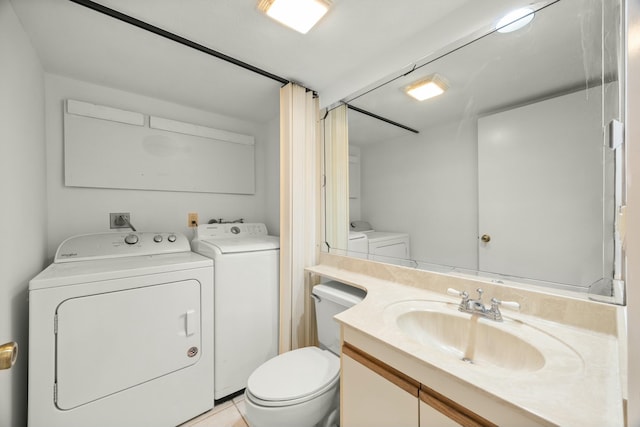 bathroom with vanity, toilet, and washer and dryer