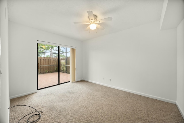 carpeted empty room featuring ceiling fan and baseboards