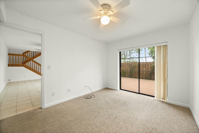 empty room with carpet flooring, a ceiling fan, and baseboards