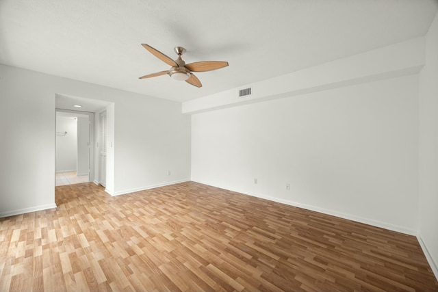 empty room featuring light wood-style flooring, visible vents, ceiling fan, and baseboards