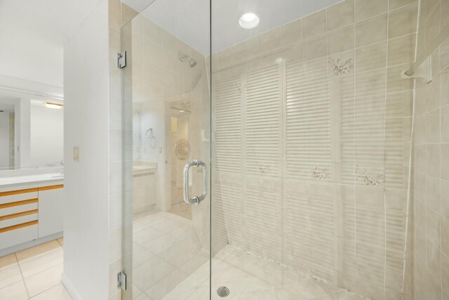 full bathroom featuring a stall shower, tile patterned flooring, and vanity