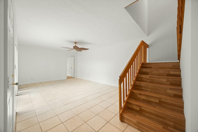 stairs with a ceiling fan and tile patterned flooring