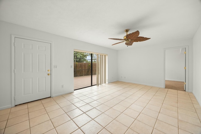 unfurnished room with light tile patterned floors, ceiling fan, and baseboards