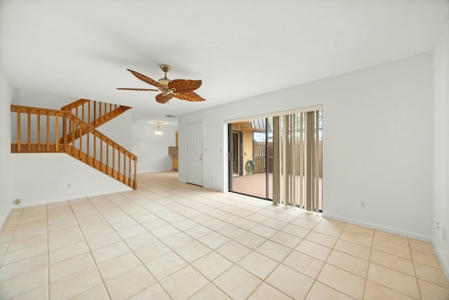 tiled spare room featuring stairs, a ceiling fan, and baseboards