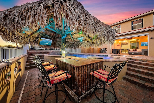 patio terrace at dusk with outdoor dry bar and fence