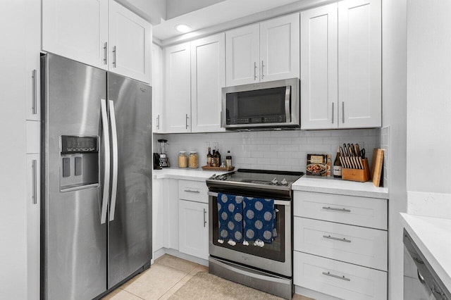 kitchen featuring light tile patterned floors, tasteful backsplash, recessed lighting, appliances with stainless steel finishes, and white cabinetry