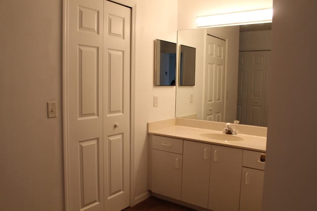 bathroom featuring a closet, vanity, and baseboards