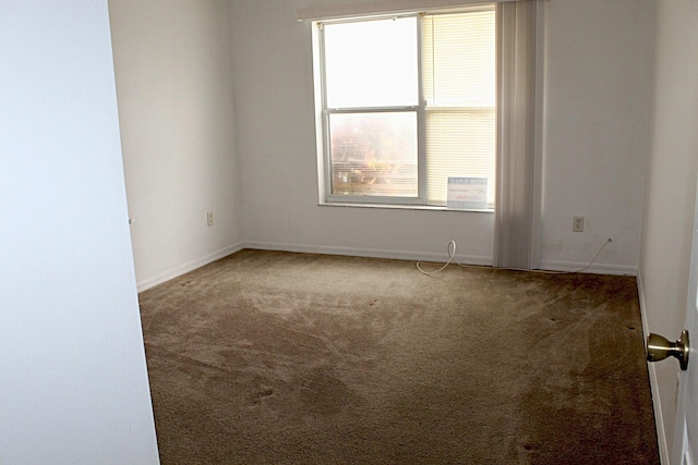 spare room with carpet and baseboards