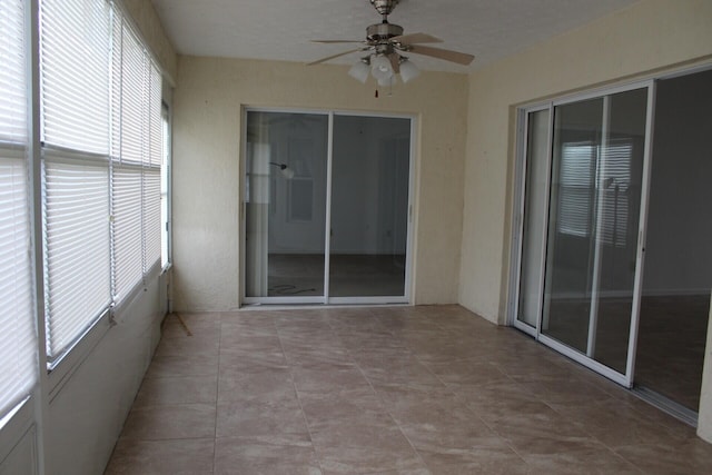 unfurnished sunroom with a ceiling fan