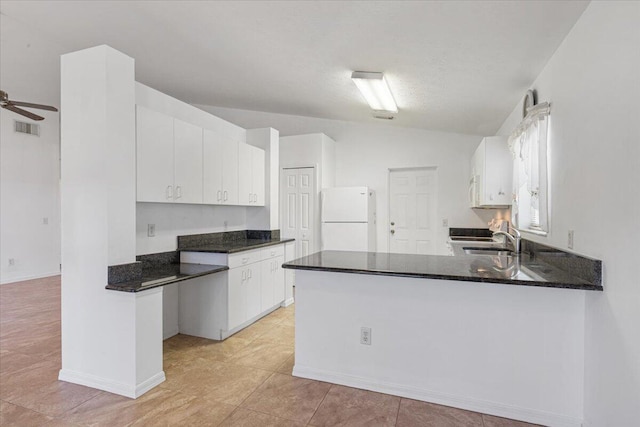 6625 Alheli Ct, Fort Pierce, FL 34951 - kitchen with visible vents, a sink, white cabinetry, freestanding refrigerator, and a peninsula