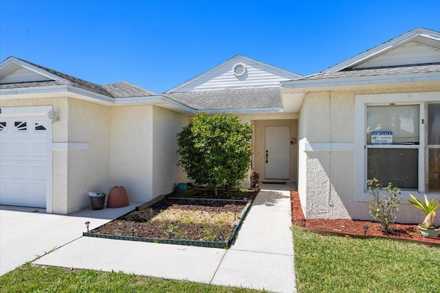 6625 Alheli Ct, Fort Pierce, FL 34951 - entrance to property featuring an attached garage, roof with shingles, and stucco siding