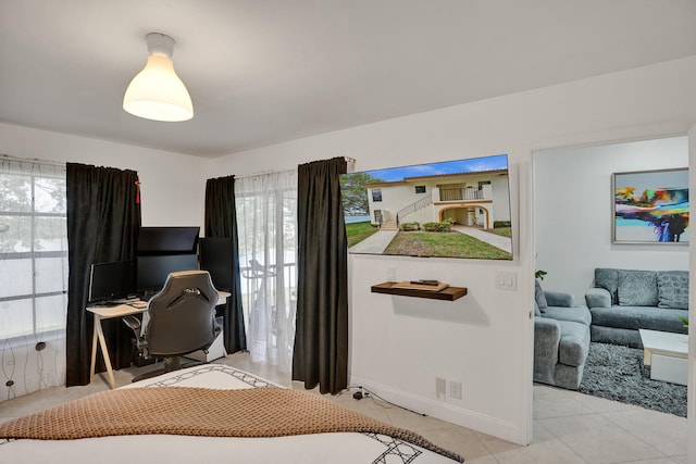 bedroom featuring light tile patterned floors and baseboards