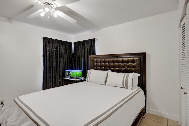 bedroom featuring light tile patterned floors, a ceiling fan, and baseboards