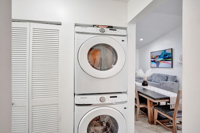 clothes washing area featuring recessed lighting, stacked washer / drying machine, laundry area, and light tile patterned floors