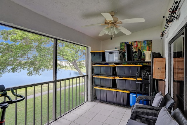 sunroom / solarium featuring vaulted ceiling, a ceiling fan, and a water view