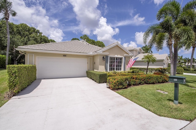 ranch-style house featuring a garage, a tile roof, concrete driveway, stucco siding, and a front yard