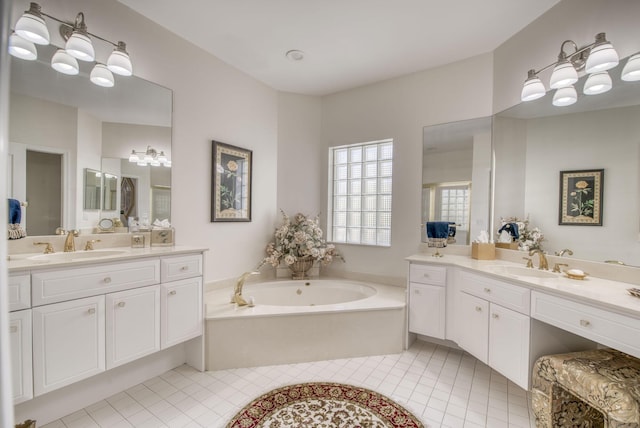 bathroom featuring two vanities, tile patterned flooring, a garden tub, and a sink