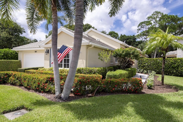 view of property exterior featuring a yard, an attached garage, and stucco siding