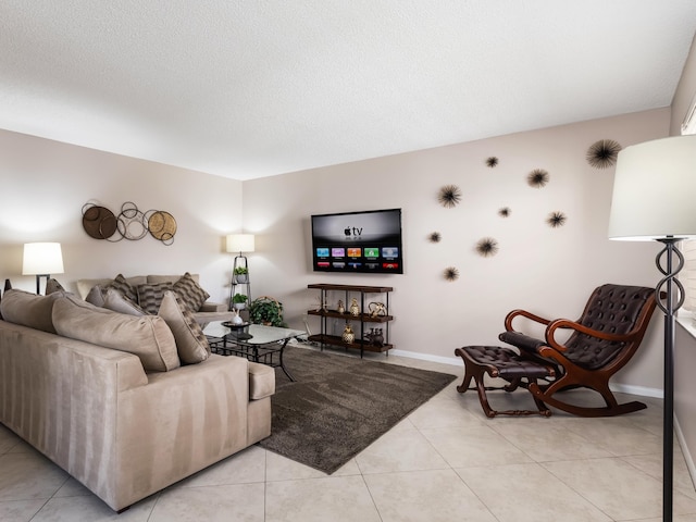 living area with light tile patterned floors, a textured ceiling, and baseboards