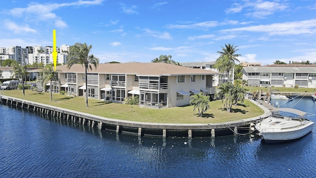 rear view of property featuring a lawn, a water view, and a residential view