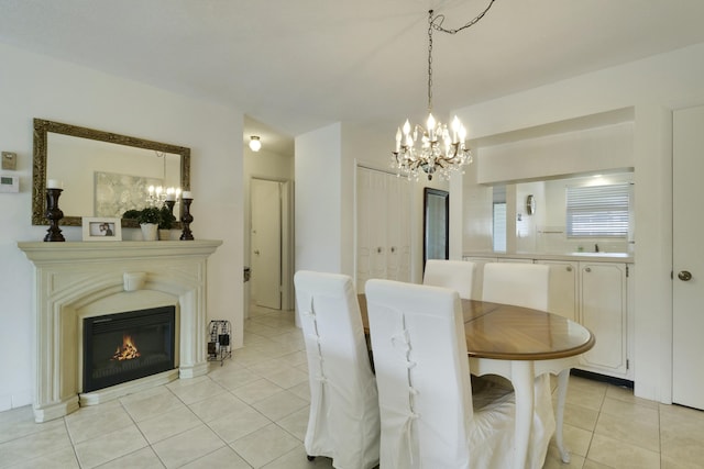 dining room with light tile patterned floors, a glass covered fireplace, and an inviting chandelier