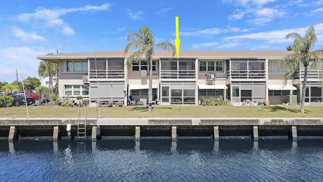 back of house featuring central air condition unit, a water view, uncovered parking, and a lawn