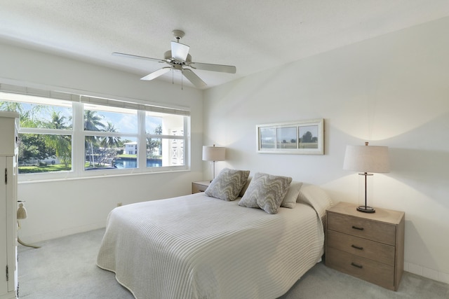 bedroom featuring a ceiling fan, light colored carpet, and baseboards