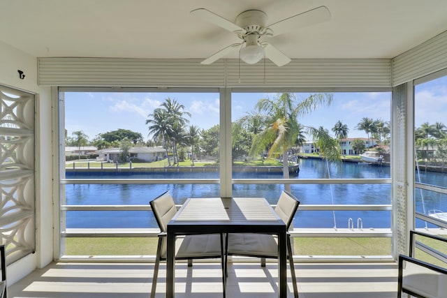 sunroom / solarium with a water view and ceiling fan