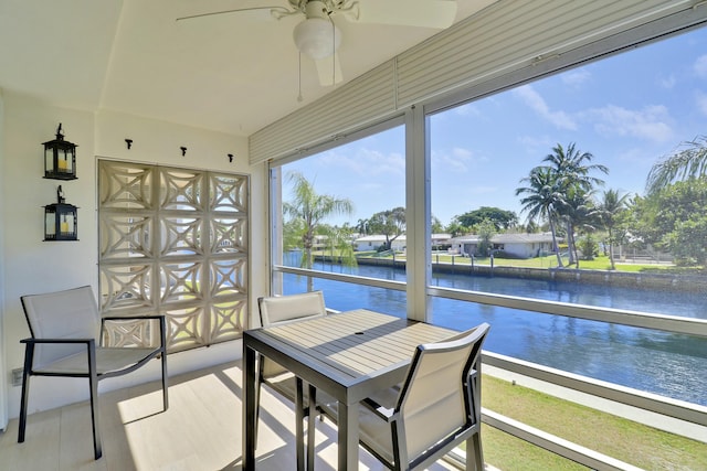 sunroom / solarium featuring a water view and ceiling fan