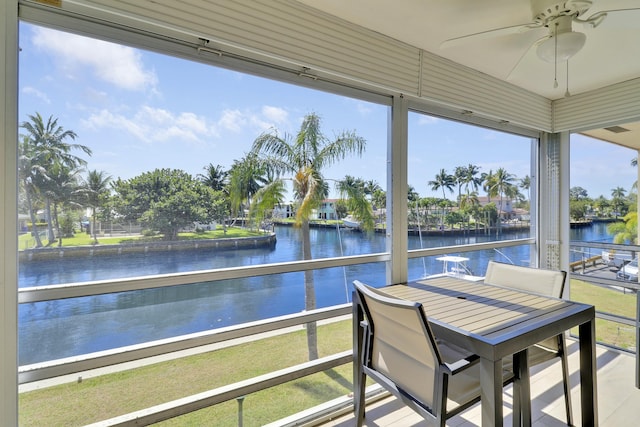 unfurnished sunroom with a water view and ceiling fan