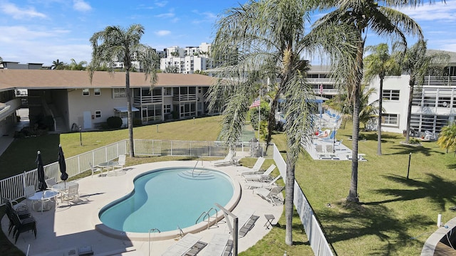 community pool with fence, a patio, and a yard