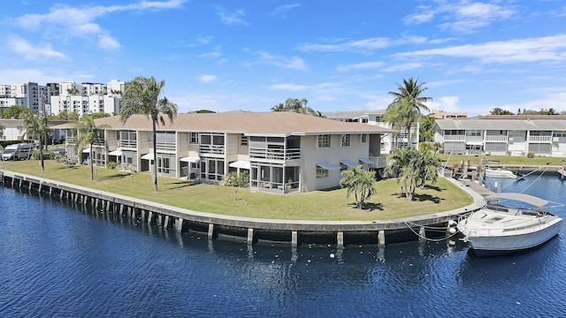 back of house featuring a residential view, a water view, and a lawn