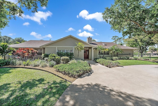 ranch-style house with a front lawn, fence, and a chimney