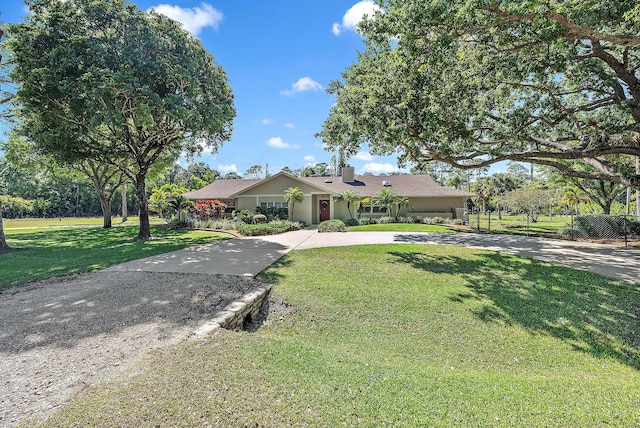 view of front of home with concrete driveway and a front lawn