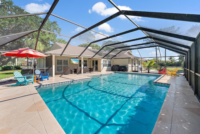 pool featuring glass enclosure and a patio