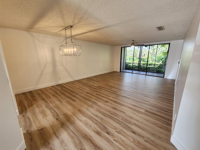 unfurnished dining area featuring visible vents, light wood-style flooring, and baseboards